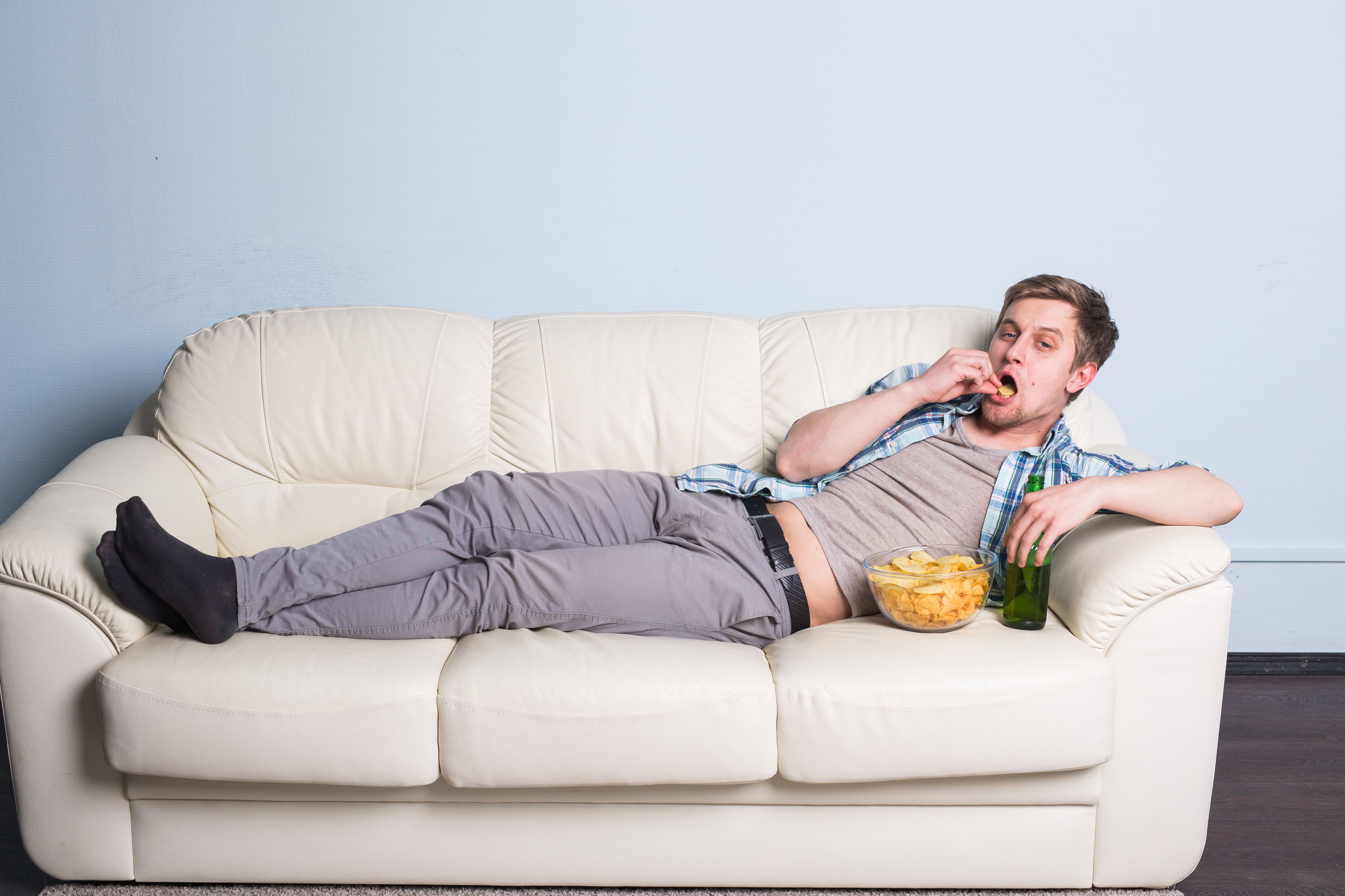 Ничем просто лежу на диване. Толстяк лежит на диване. Мужчина на диване с пивом. Мужикмна Ливане с пмвом. Ленивый человек.
