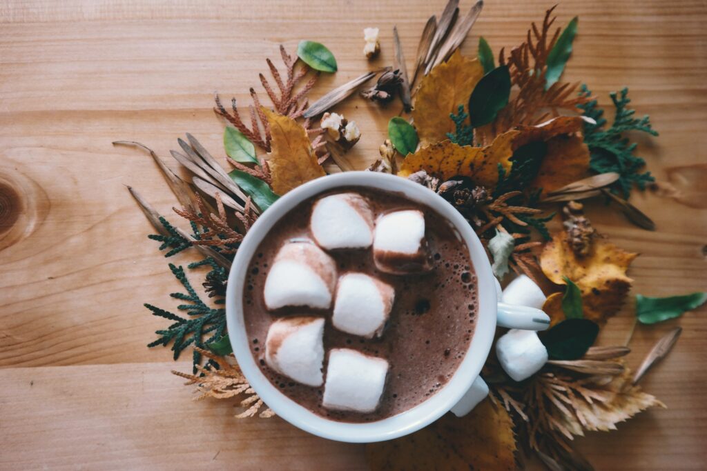Mug of dark hot chocolate in the middle of a decorative table wreath.