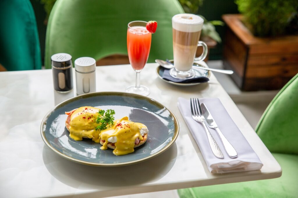 Eggs Benedict served with a strawberry lemonade and latte.