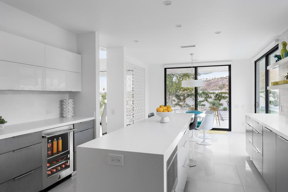 A white kitchen built with JennAir a beverage cooler, a dishwasher, and an undercounter microwave.