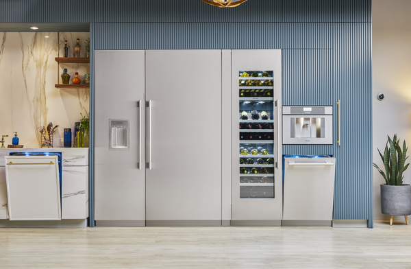 From left to right, a Thermador dishwasher, column freezer, built-in refrigerator, wine cool, built-in coffee maker, and built-in dishwasher installed in a designer kitchen.